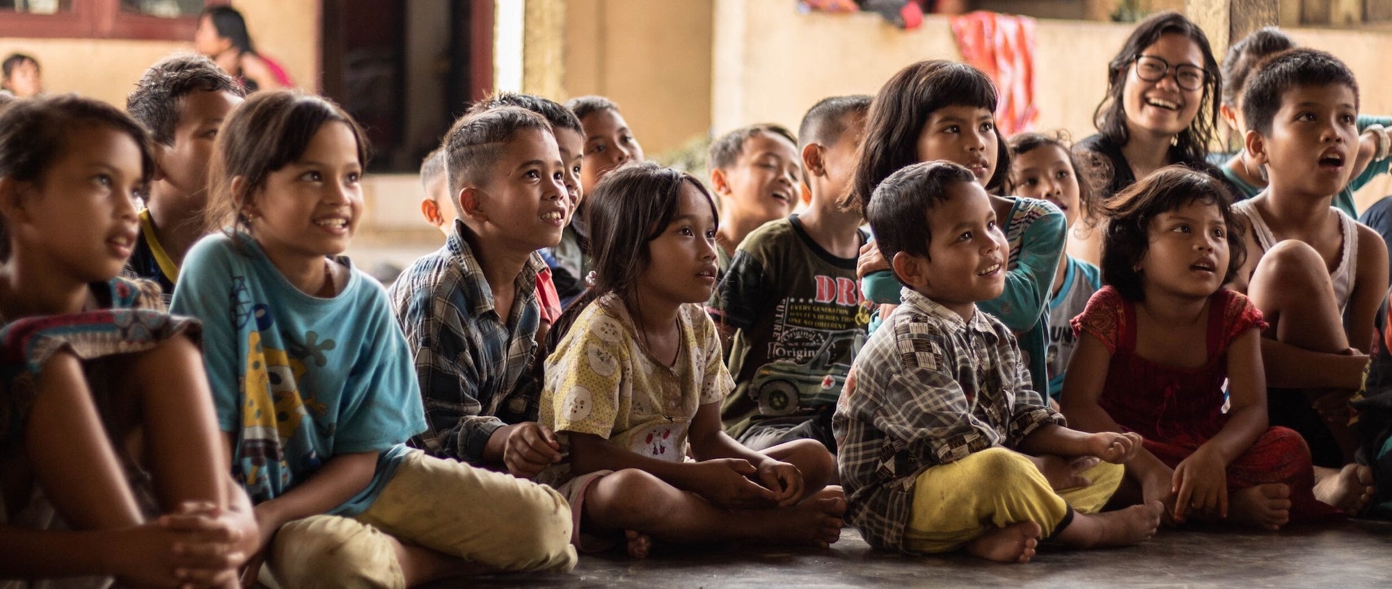 stock photo of dark skinned children in a group, looking up laughing and smiling